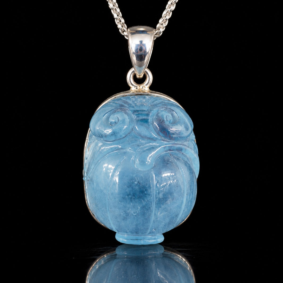 Carved blue aquamarine pendant in sterling silver, front view. Item 893570.
