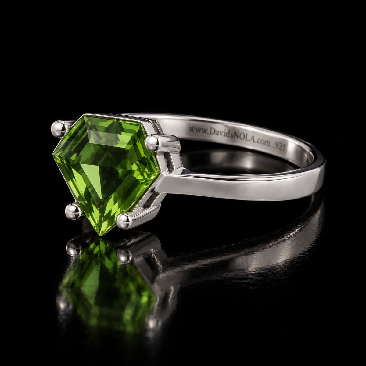 VooDooStone shield-cut ring in peridot green, angled side view. Item 894787.