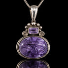Vintage sterling silver pendant with purple charoite oval and amethyst accent, front view. Item 893725.