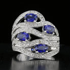 A vintage sapphire and diamond ring with a cascading design, featuring blue sapphires and round diamonds set in 14K white gold.