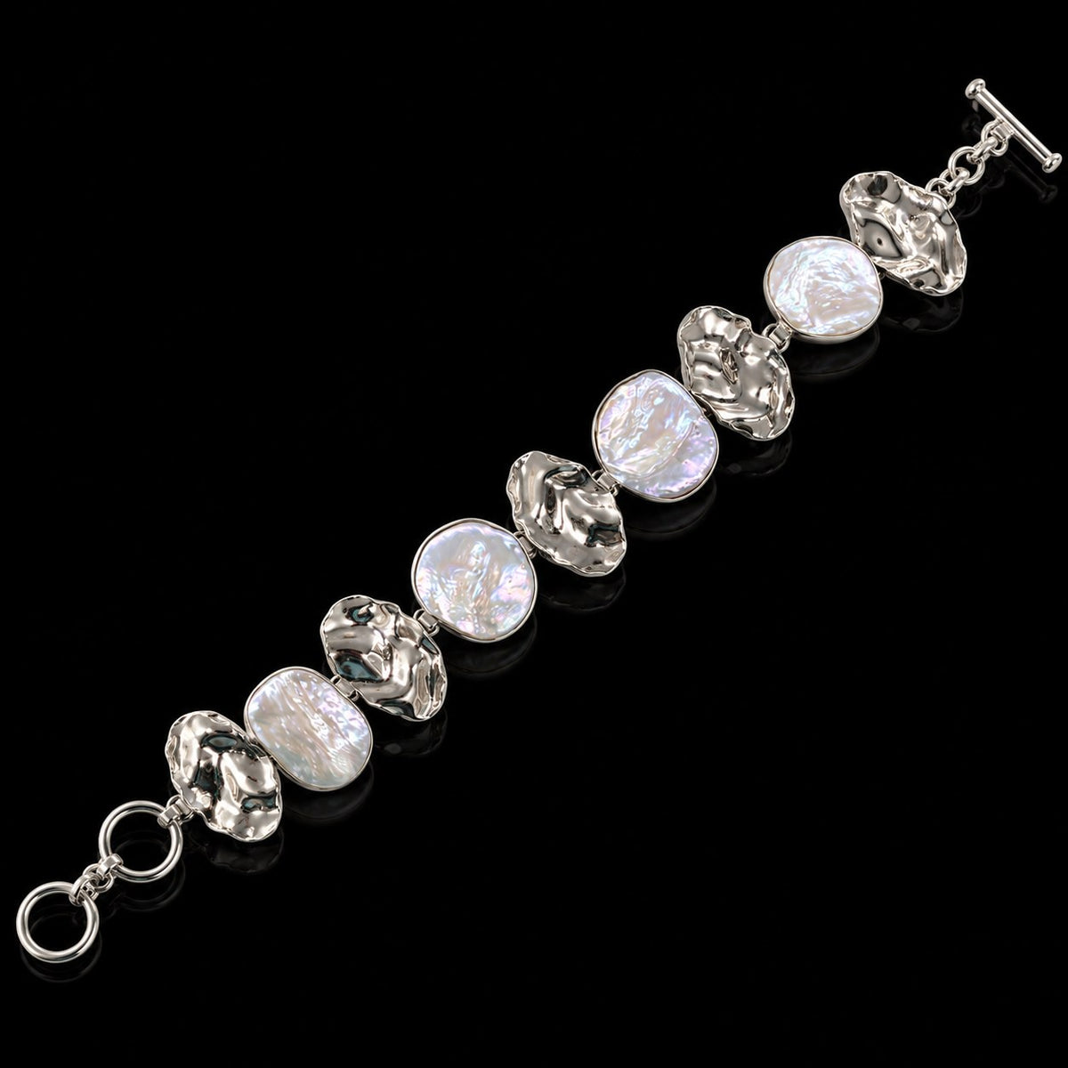 Sterling silver bracelet with oval blister pearls and ornate silver links, toggle clasp. Item 894012.
