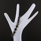 Garnet line bracelet draped on a display hand, side view. Item 894562.