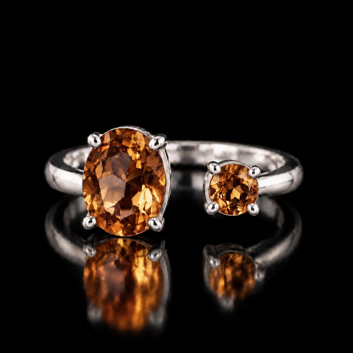 VooDooStone open gap ring in sterling silver, stones golden amber under warm indoor light, front view