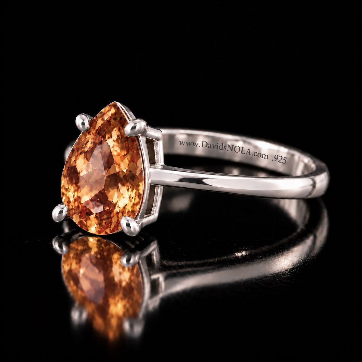The same VooDooStone pear-cut solitaire ring in golden amber, angled side view. Item 894782.