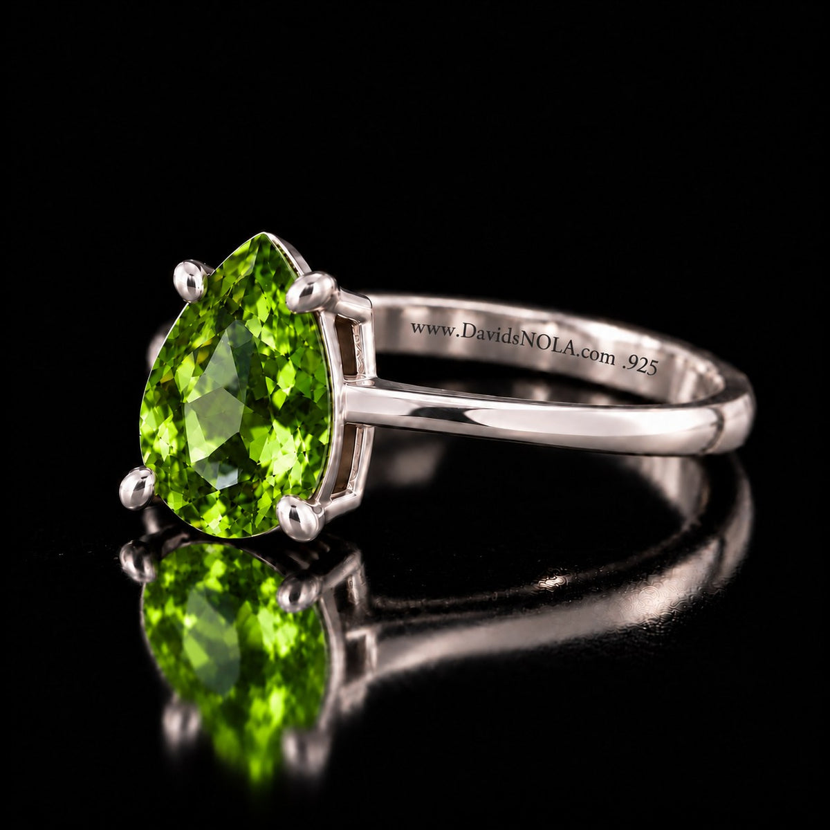 The same VooDooStone pear-cut solitaire ring in peridot green, angled side view. Item 894782.