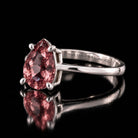 Sterling silver VooDooStone pear-cut solitaire ring, purplish-pink daylight colour, angled side view showing the six prongs and slim band. Item 894782.