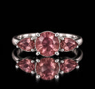 Sterling silver VooDooStone three-stone ring, round center stone with pear side stones, all purplish-pink in daylight, front view. Item 894786.