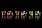 All three colors of the one pair of VooDooStone heart-cut studs side by side: purplish-pink daylight, golden amber incandescent, peridot green fluorescent. Item 894788.
