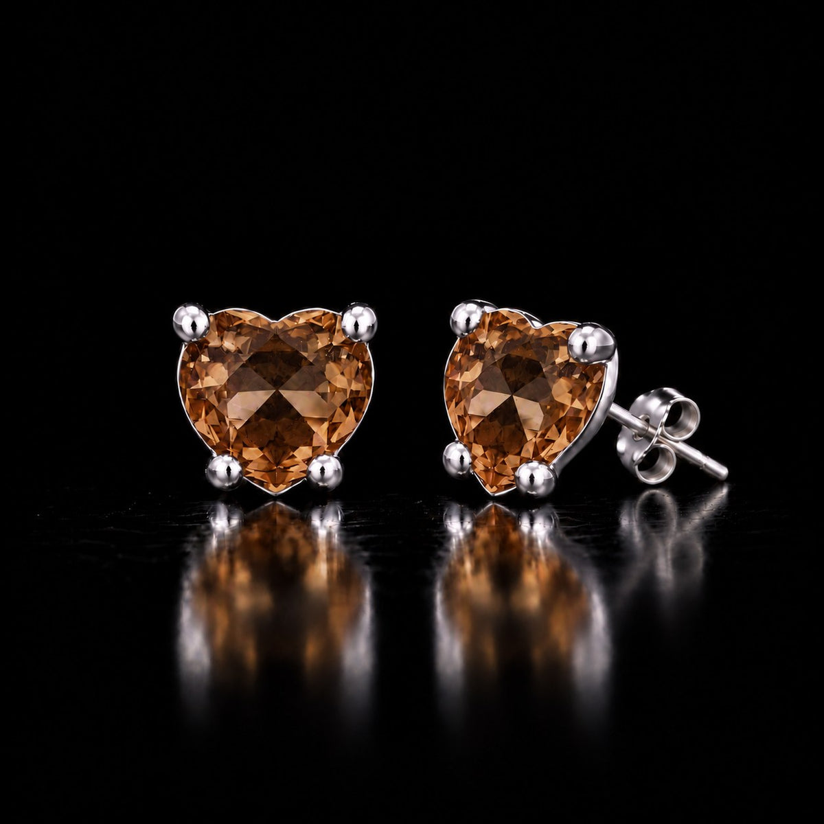 The same VooDooStone heart-cut stud earrings turning golden amber under warm incandescent light. Item 894788.