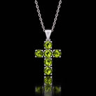 The same VooDooStone cross pendant turning peridot green under fluorescent light. Chain shown for scale, not included. Item 894790.